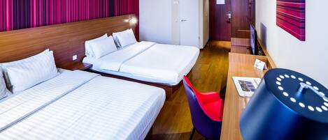 Een hotelkamer met twee bedden, een bureau, een stoel en een klok.