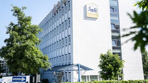Um edifício de hotel com uma placa que diz 'StarG Hotel Collection'.