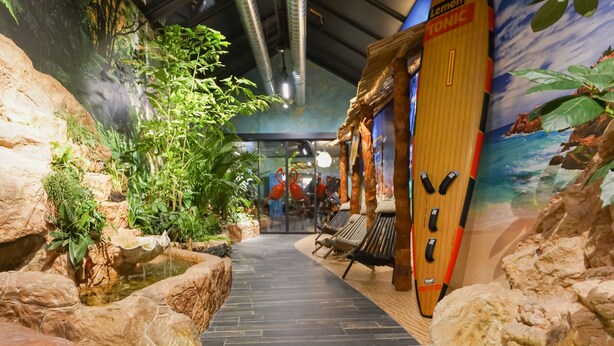 Un passage intérieur, avec un mur de pierres d’un côté et une fresque de l’autre.