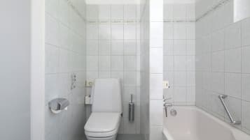 Une salle de bain moderne équipée de toilettes, d’un bidet et d’une baignoire.