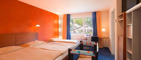 Une chambre d’hôtel avec deux lits, un bureau, une chaise et une armoire.
