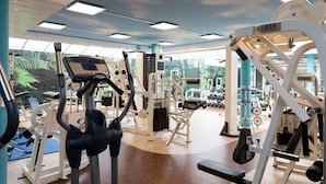 Une salle de sport équipée de divers appareils d’exercice, notamment des tapis de course et des appareils de musculation.