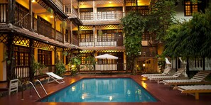 A multi-level pool area with wooden railings and lounge chairs. - Protea Hotel by Marriott Dar es Salaam Courtyard (Dar es Salaam)