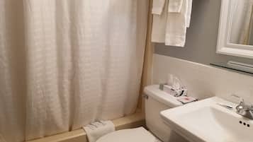 Un baño con bañera, inodoro y lavamanos.