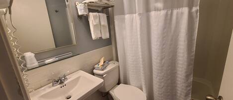 A bathroom with a sink, toilet, and shower curtain.
