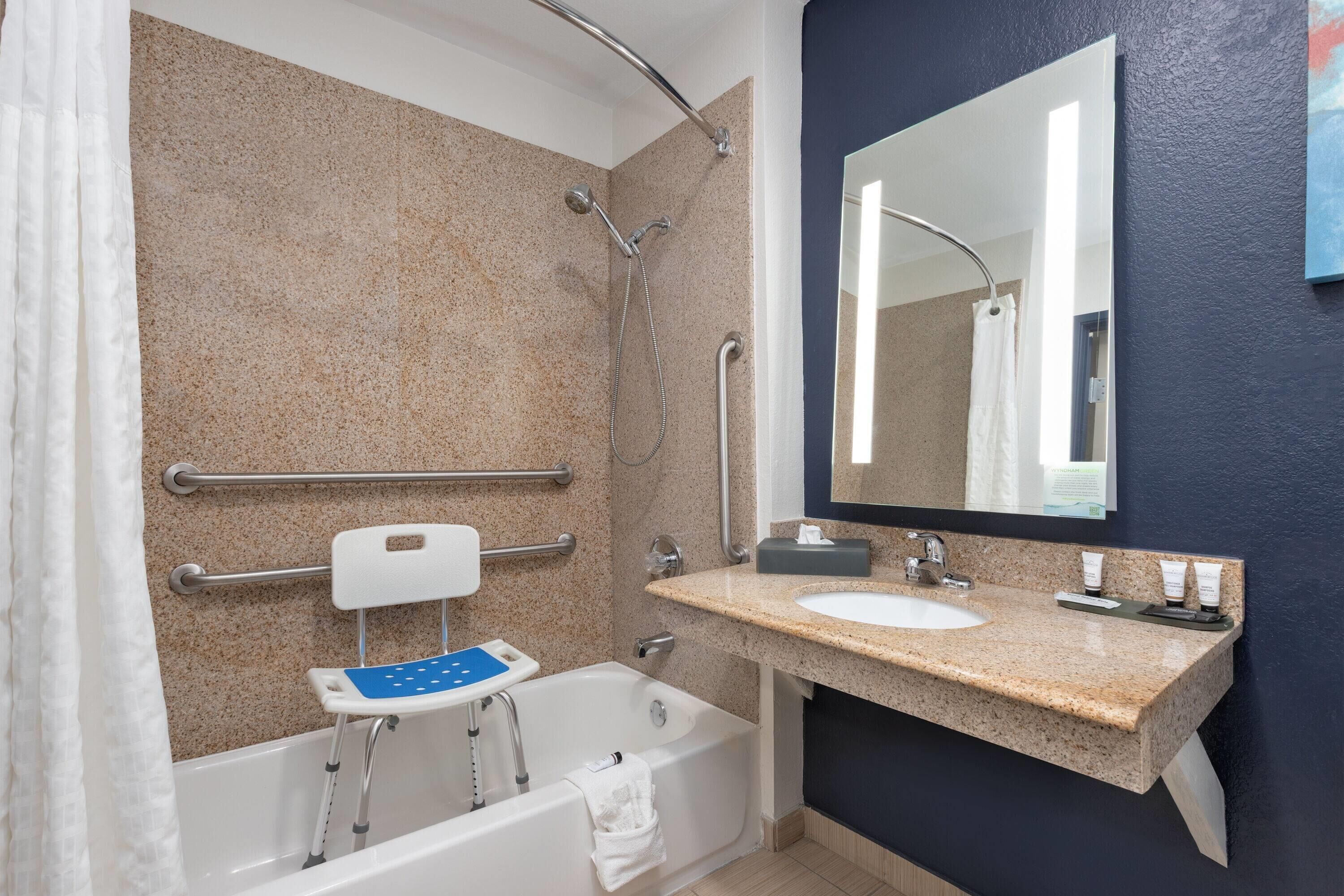 A bathroom with a bathtub, a sink, a mirror, and a shower.