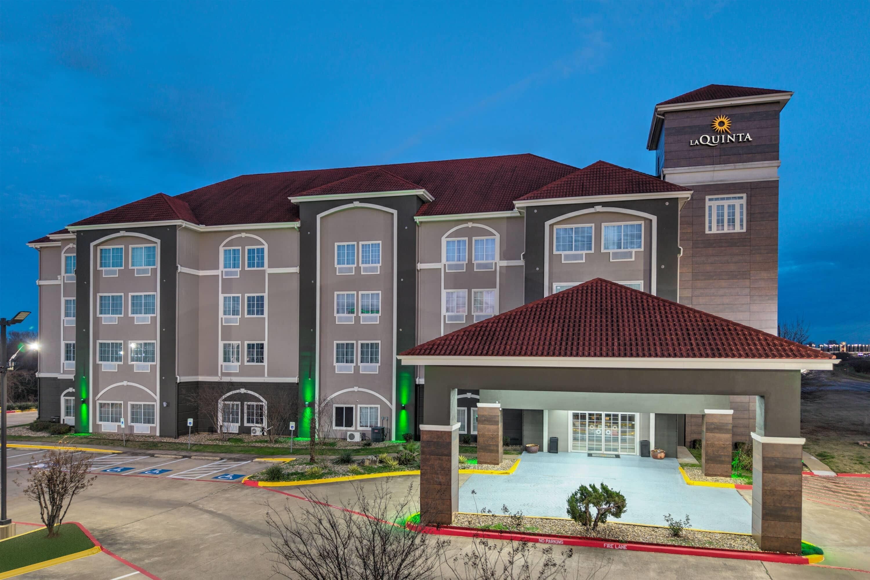 A multi-story hotel with a flat roof and a covered entrance area.