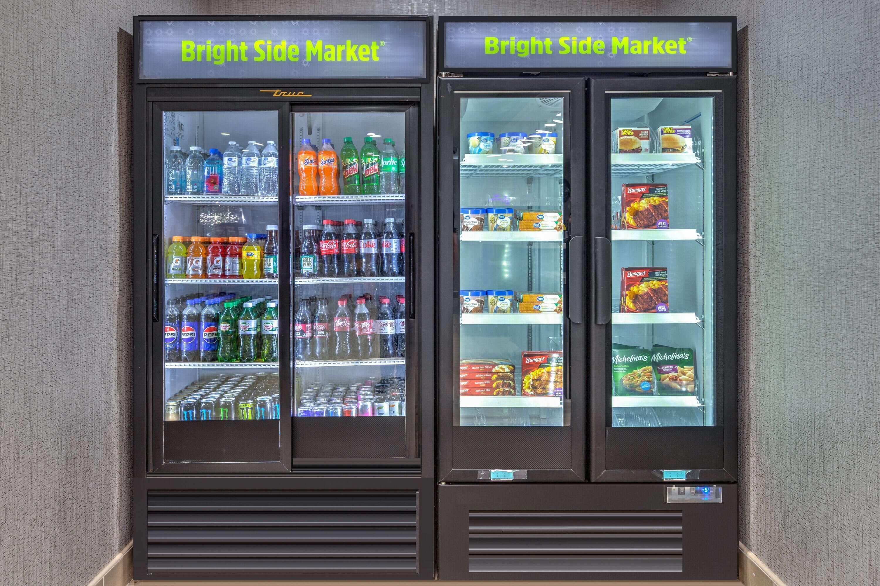 Two vending machines labeled "Bright Side Market" with various beverages and snacks inside.