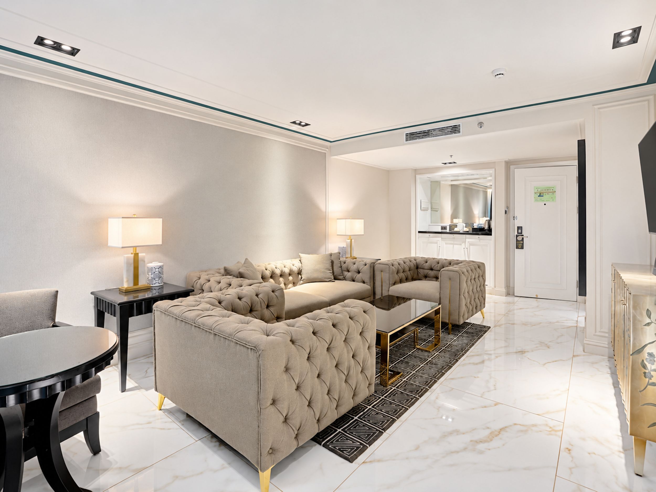 A modern living room with a sectional sofa, a coffee table, and a dining table.