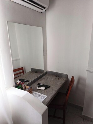 A small, clean room with a simple table, a chair, and a large mirror. - Hotel Playa Club (Cartagena)