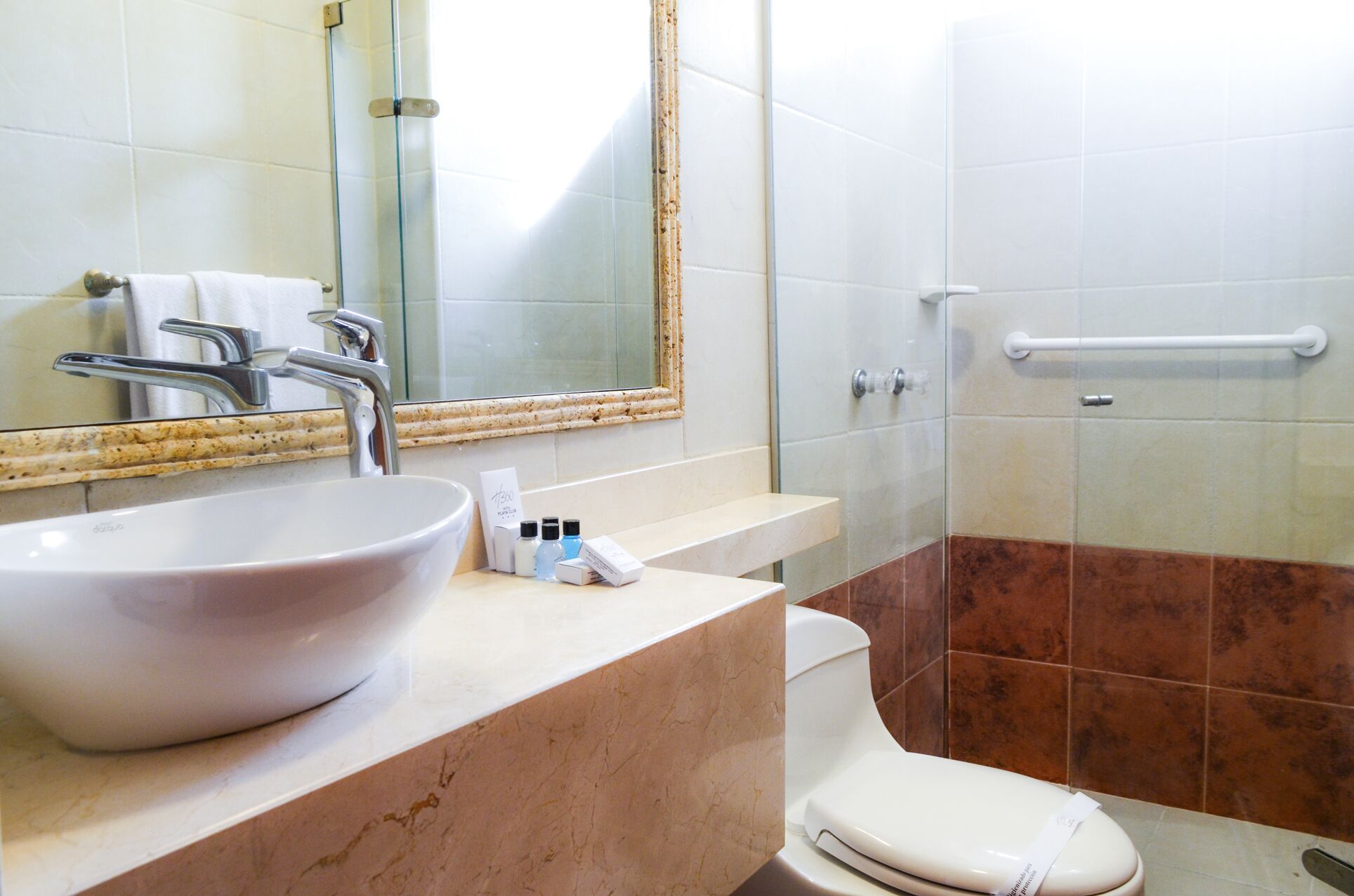 Un baño con un lavamanos grande blanco, un espejo, un inodoro y una zona de ducha.