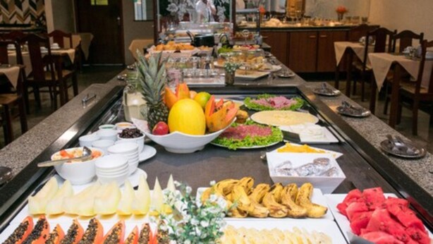 A buffet with various food items including fruits, vegetables, and meats. - Hotel Vale Verde (Campo Grande)