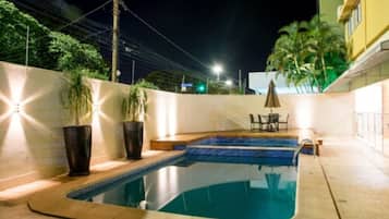 Alberca al aire libre y camastros