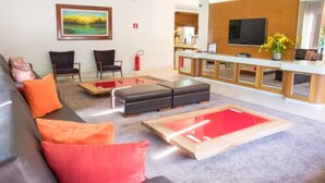 A modern lobby with a reception desk, seating area, and a large painting on the wall. - Hotel Vale Verde (Campo Grande)