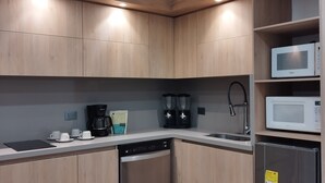 Una cocina moderna con armarios de madera, lavavajillas, cafetera y microondas.