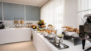 Een ontbijtbuffet met diverse soorten eten en een koffieapparaat.