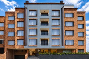 Un hôtel à plusieurs étages, doté d’une façade en briques, de grandes fenêtres et d’une entrée centrale avec un escalier.