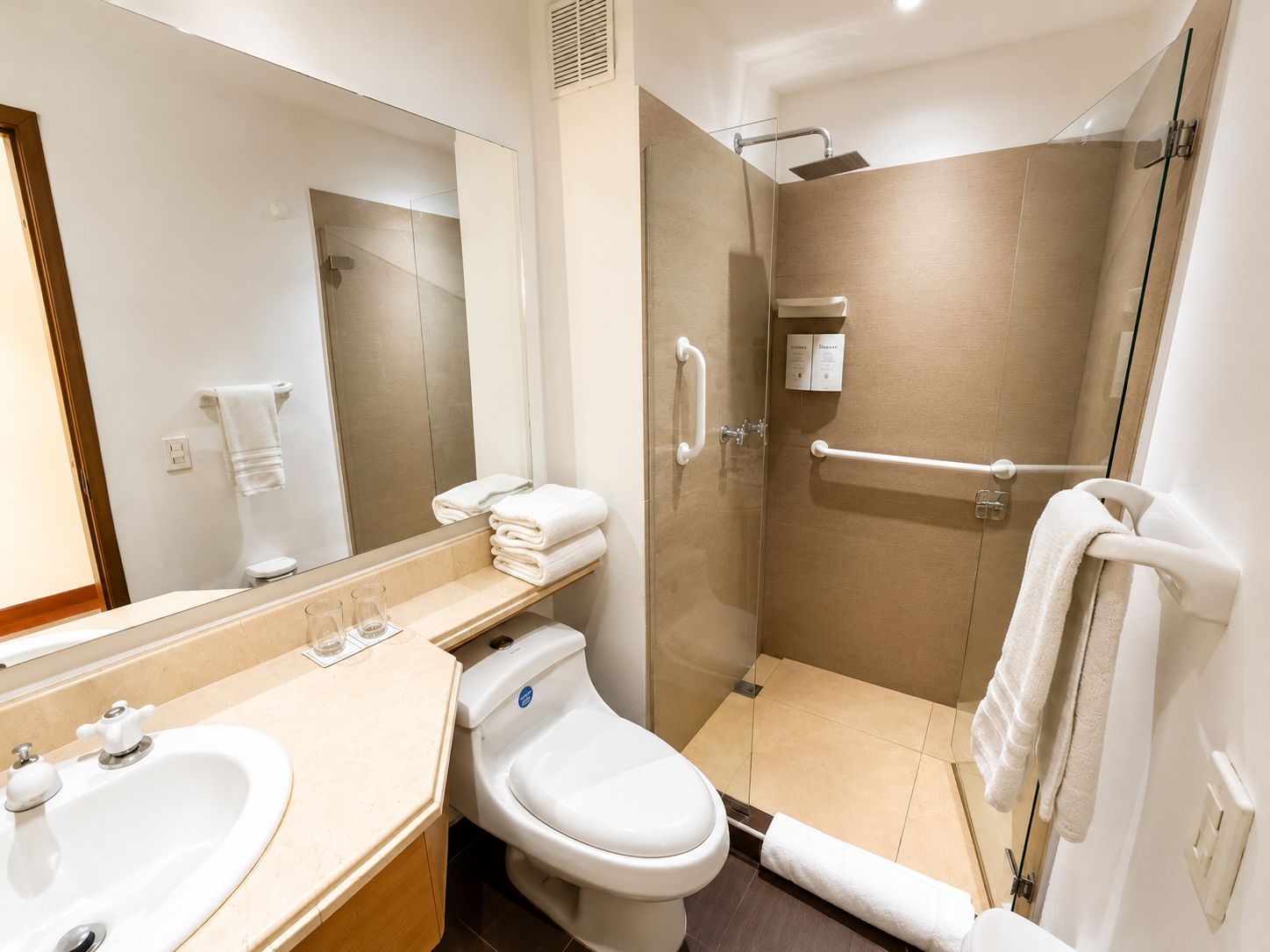 A modern bathroom with a sink, toilet, and shower.