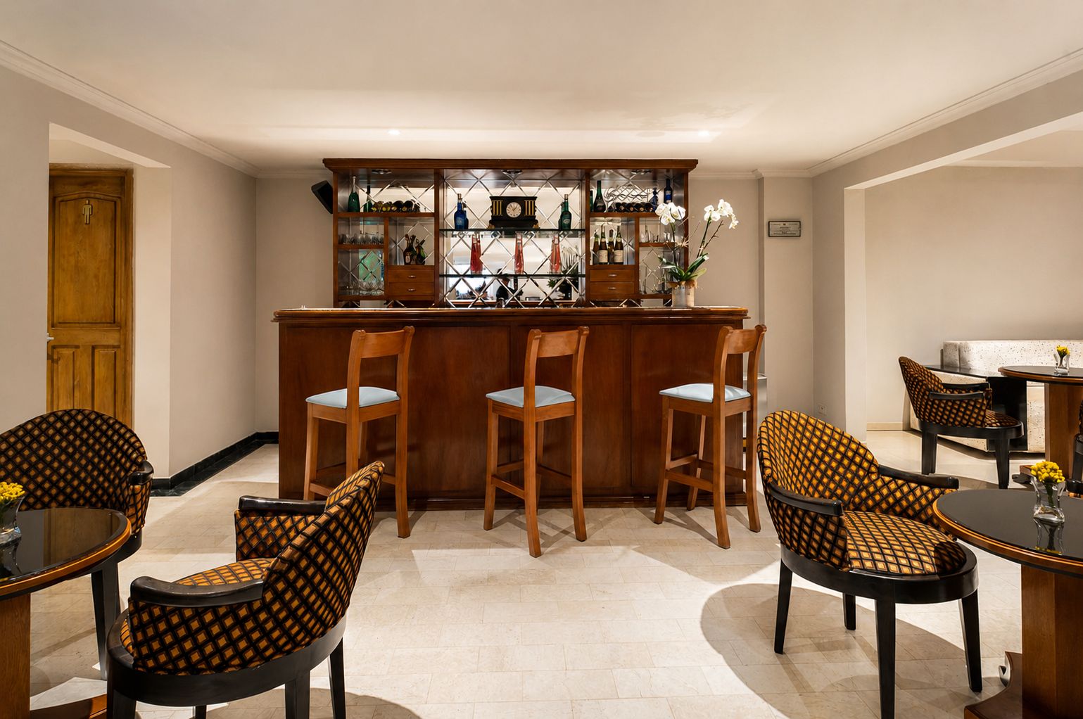 Uma área de bar com cadeiras de madeira e balcão.