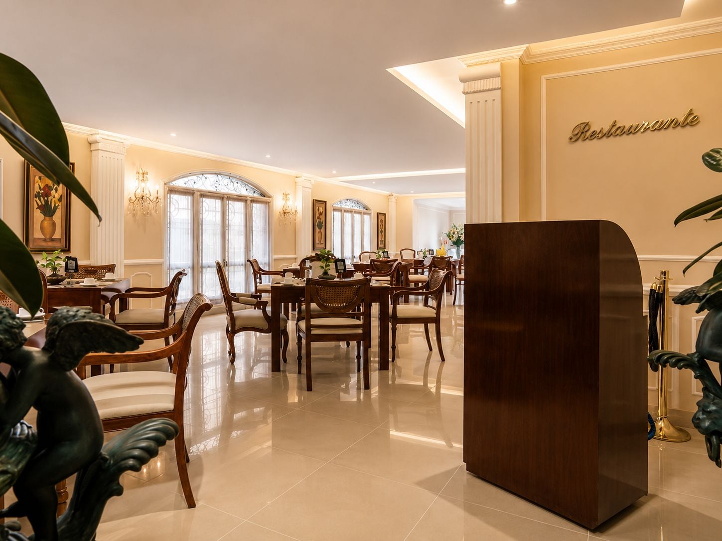 Un comedor amplio con una gran mesa de madera y sillas, un pilar decorativo y un letrero en la pared que dice 'Restaurantante'.