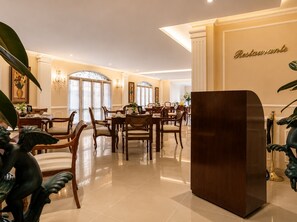 Un comedor amplio con una gran mesa de madera y sillas, un pilar decorativo y un letrero en la pared que dice 'Restaurantante'.