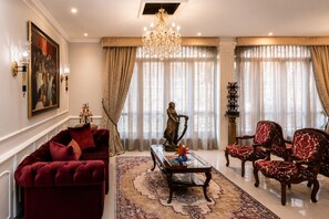 Amplia sala de estar con un sofá rojo, una mesa de centro y una estatua.