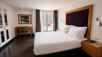 Une chambre d’hôtel avec un grand lit, un bureau, une chaise et une vue sur l’extérieur.