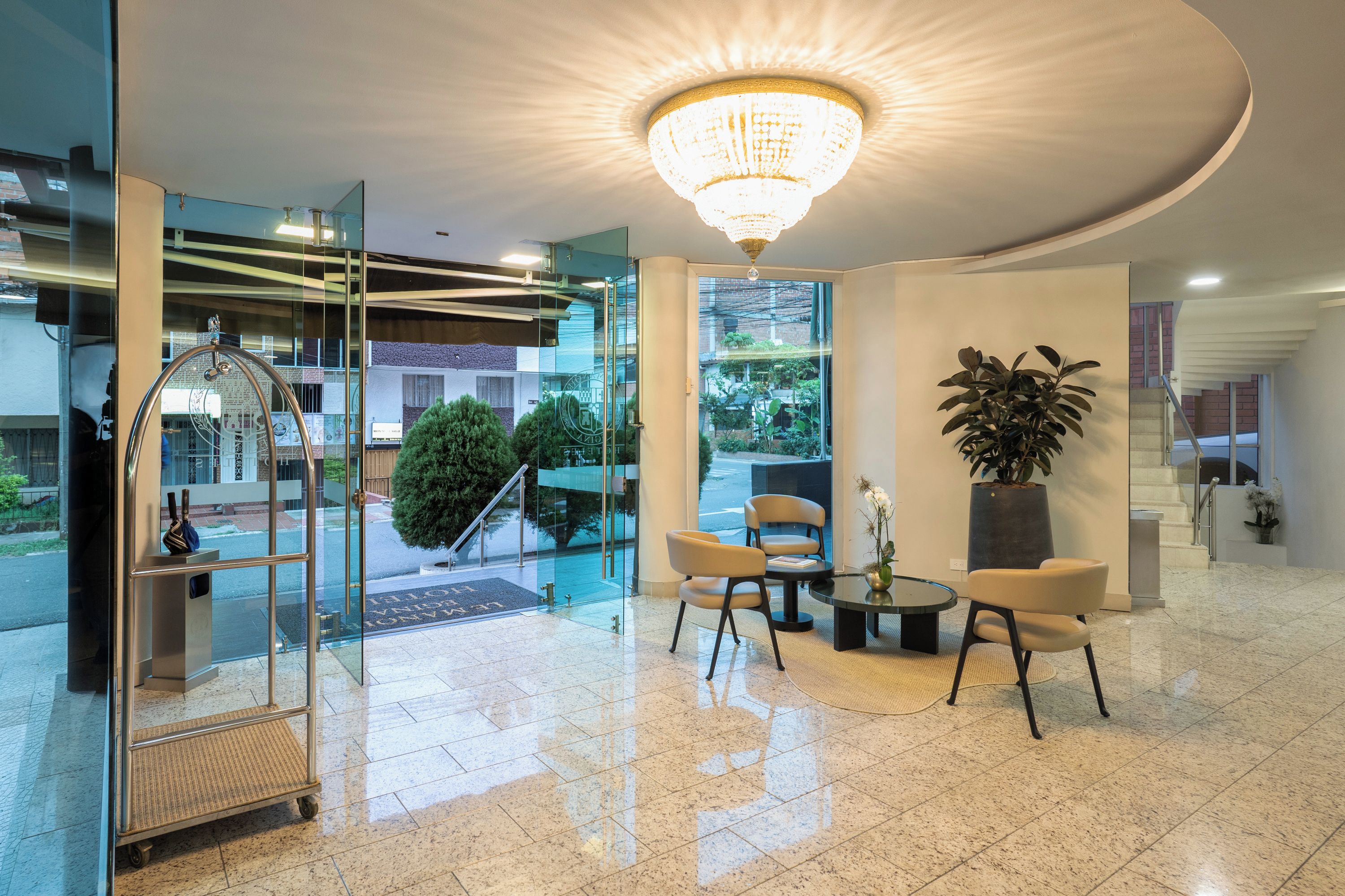 Um hall de hotel com balcão de recepção, área de estar e um grande candelabro.