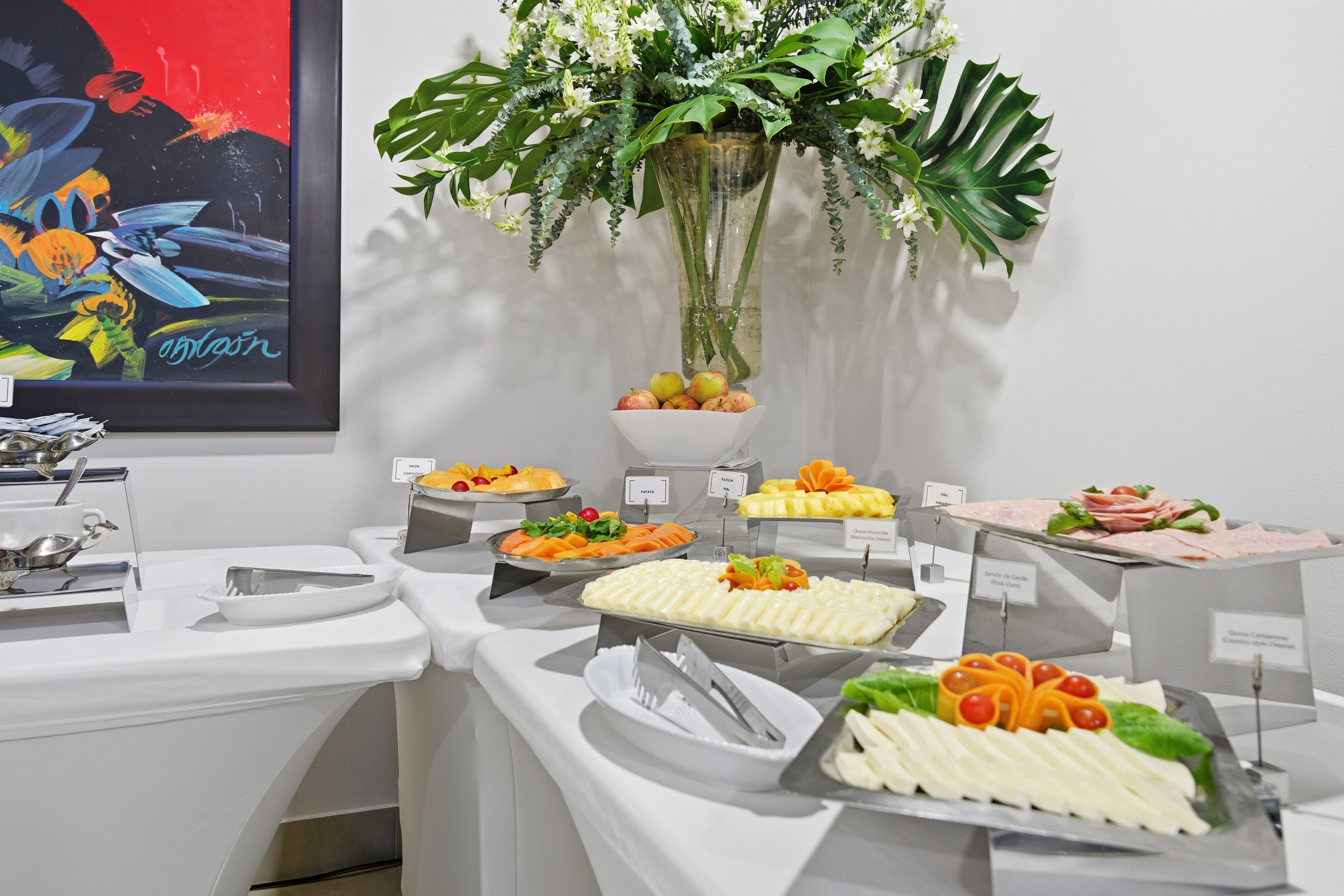 A buffet setup with various food items and a decorative plant.