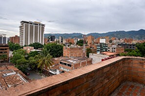 Un hotel moderno de gran altura con varios pisos, rodeado de otros edificios y áreas verdes.
