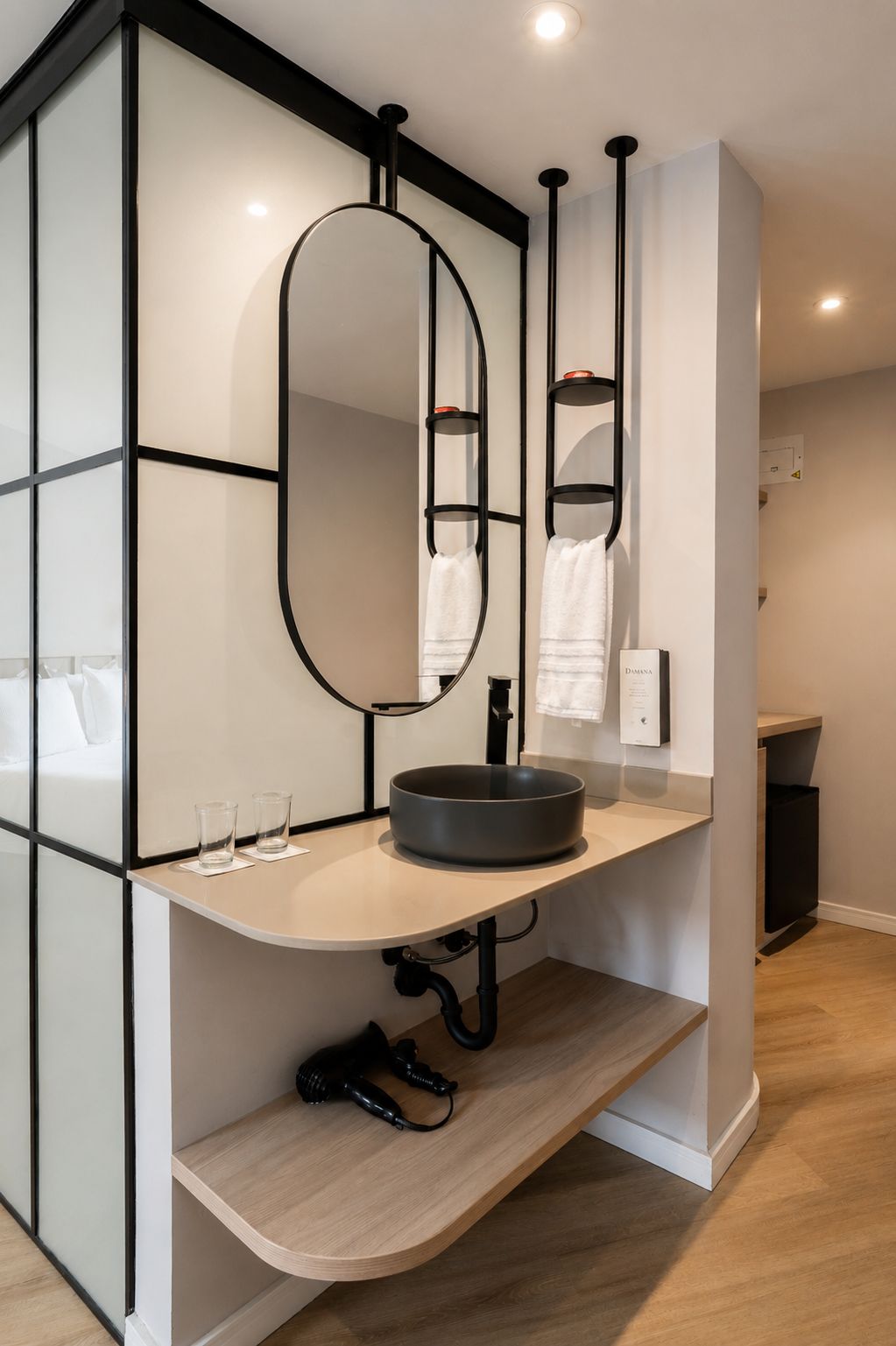 Une salle de bain moderne avec un lavabo rond, un grand miroir et un porte-serviettes.