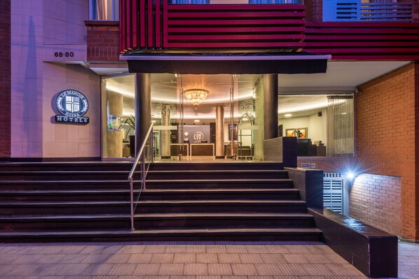 A hotel entrance with a modern design, featuring a staircase leading to the lobby, a chandelier, and a sign indicating the hotel's name. - Hotel Egina Medellín (Medellín)