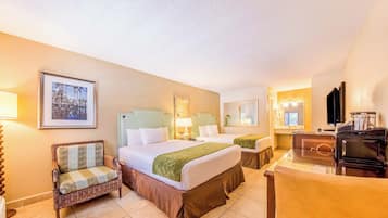 Une chambre d’hôtel avec deux lits, une chaise, un bureau et un téléviseur.