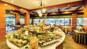 A buffet with various food items and a large decorative tree centerpiece. - The Qamar Paka (Dungun)