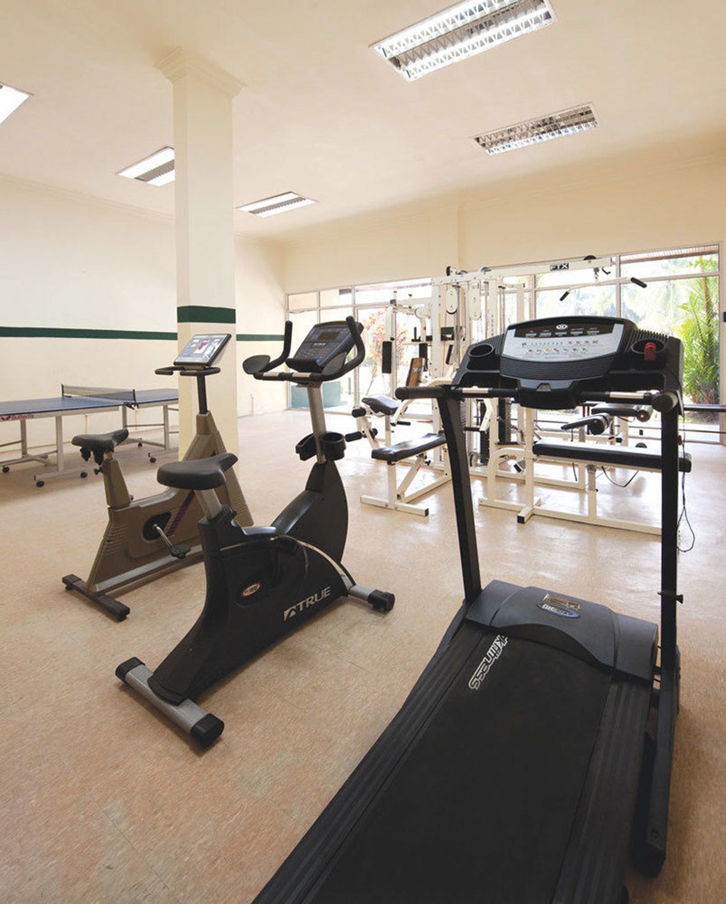 A gym with various exercise equipment including treadmills and an elliptical machine.