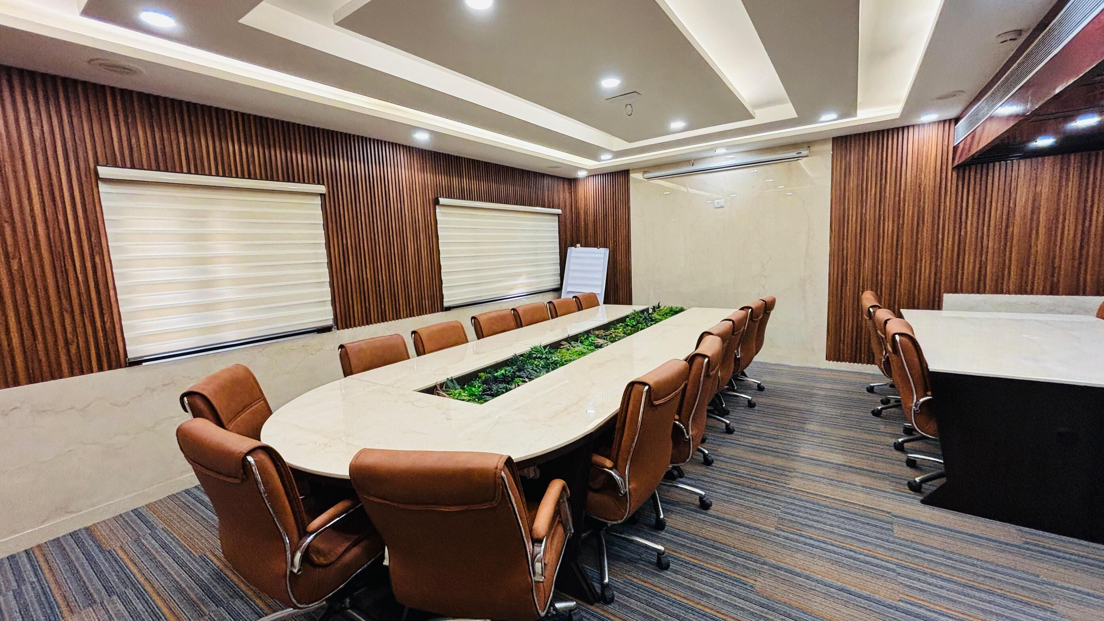 A conference room with a long table, brown leather chairs, and a whiteboard.