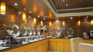 A buffet area with a variety of food items and a seating area. - Hotel Shanti Palace (New Delhi)