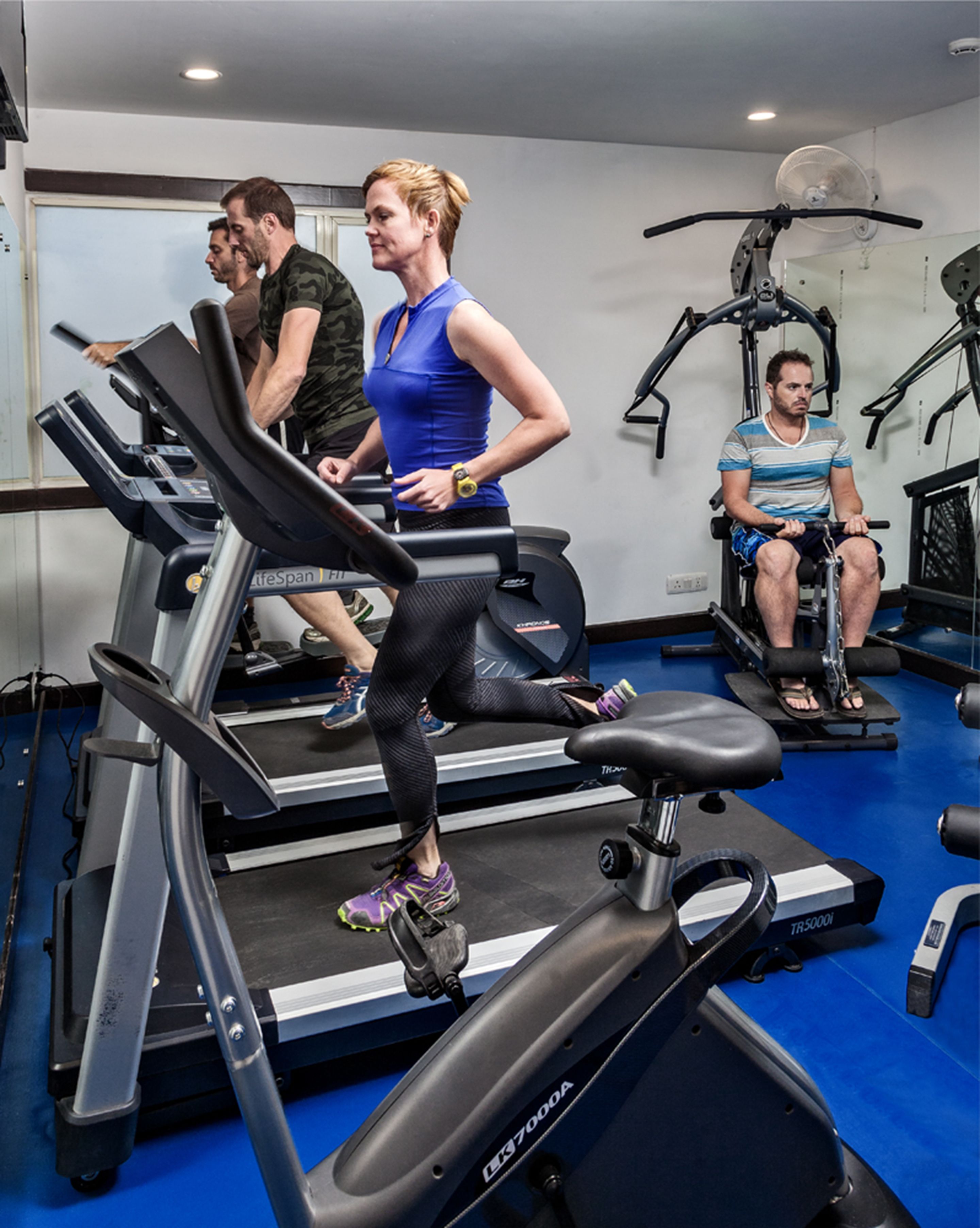 A gym with treadmills, stationary bikes, and a rowing machine.