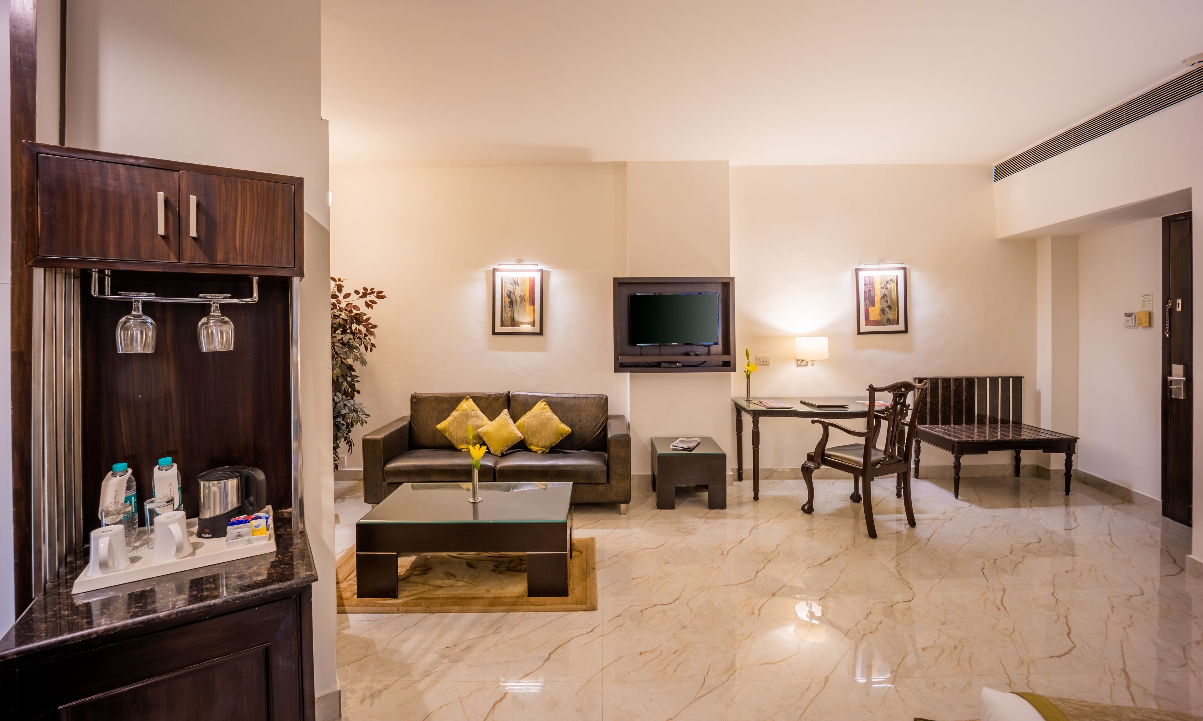 A modern living room with a sofa, coffee table, TV, and a dining area.