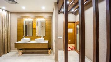 A modern bathroom with two sinks, a large mirror, and wooden paneling on the walls.
