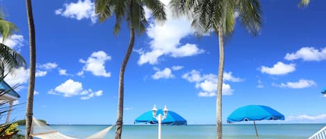 Sur la plage, chaise longue, parasol, serviettes de plage