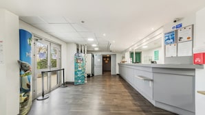 Eine saubere, moderne Lobby mit Holzboden, einer Rezeption und Informationspostern an den Wänden.