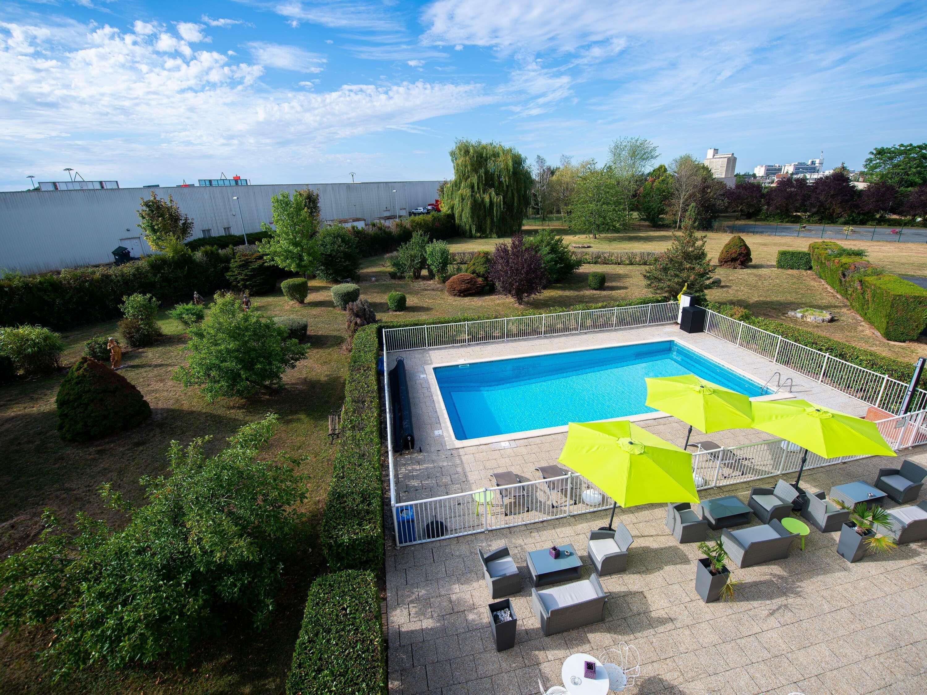 Una piscina con zona de terraza cercada, mobiliario exterior y vistas del paisaje circundante.
