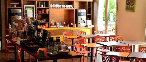 Un café moderno con armarios de madera, sillas anaranjadas y una variedad de electrodomésticos de cocina.