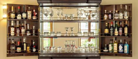 A bar area with shelves of liquor bottles and glasses.