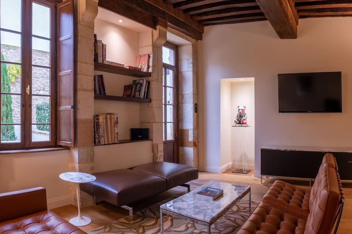 A living room with a sofa, a coffee table, a TV, and bookshelves.