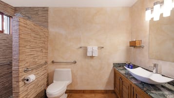 Ein Badezimmer mit Dusche, Toilette, Waschtisch und Spiegel.