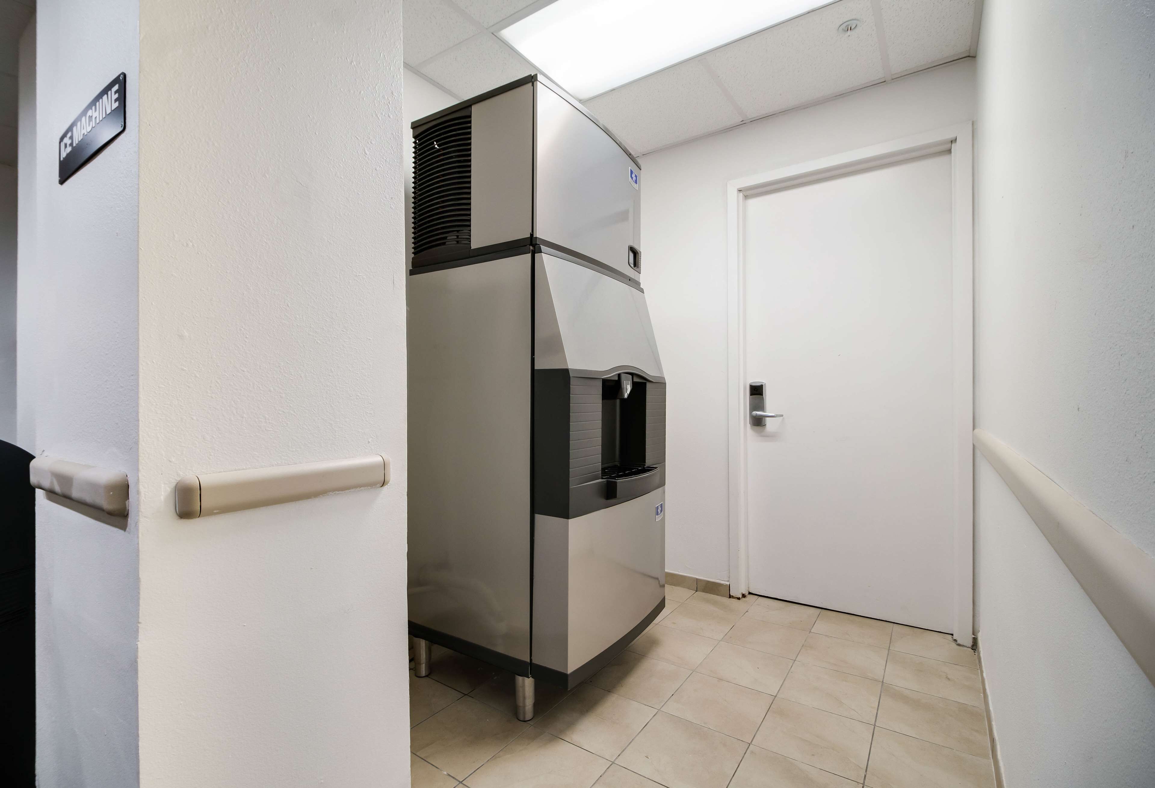 A compact kitchen with a built-in refrigerator and a microwave.