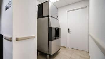 A compact kitchen with a built-in refrigerator and a microwave.