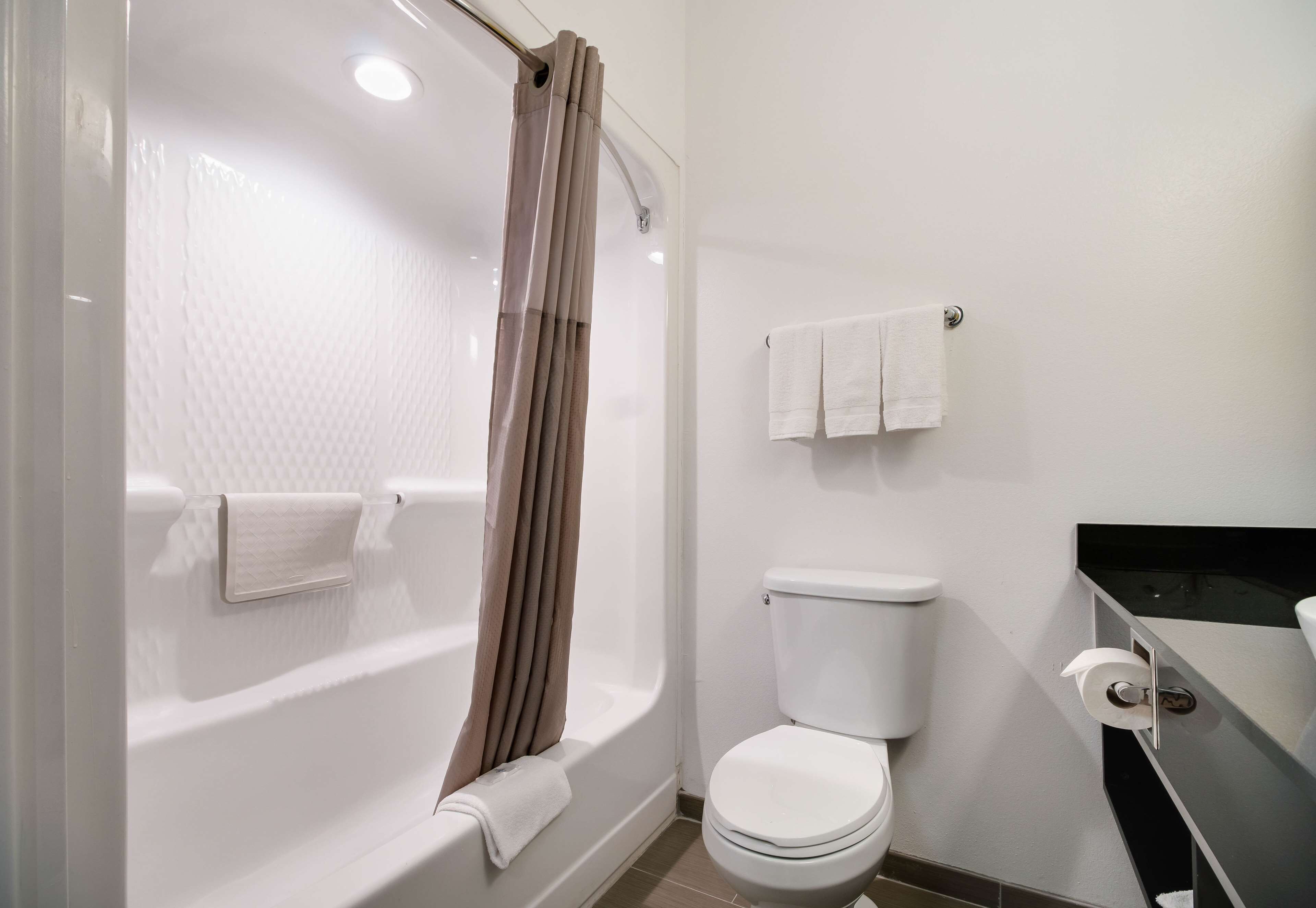 Un baño moderno con bañera, inodoro y barra para toallas.